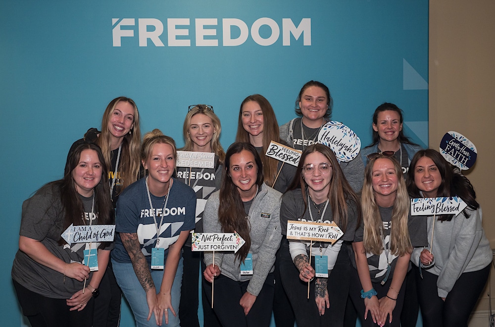 A group of women smiling and posing for a photo at the Freedom Conference.