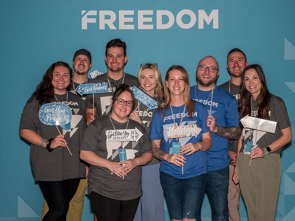 A group of women smiling and posing for a photo at the Freedom Conference.